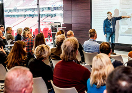 Firmenevent im RheinEnergieSTADION mit Zuhörern einer Präsentation