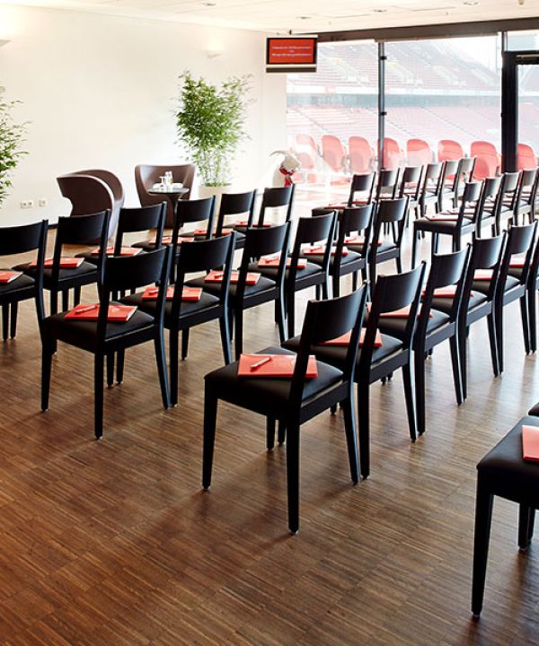 Empty rows of seats in front of a presentation in the Zentralloge Nord of the RheinEnergieSTADION